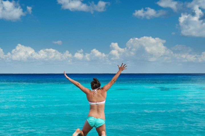 a woman standing next to a body of water