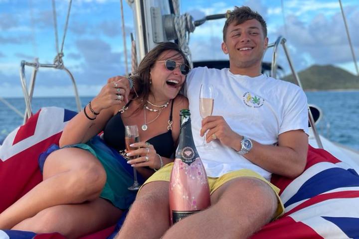 a man and woman sitting next to a body of water
